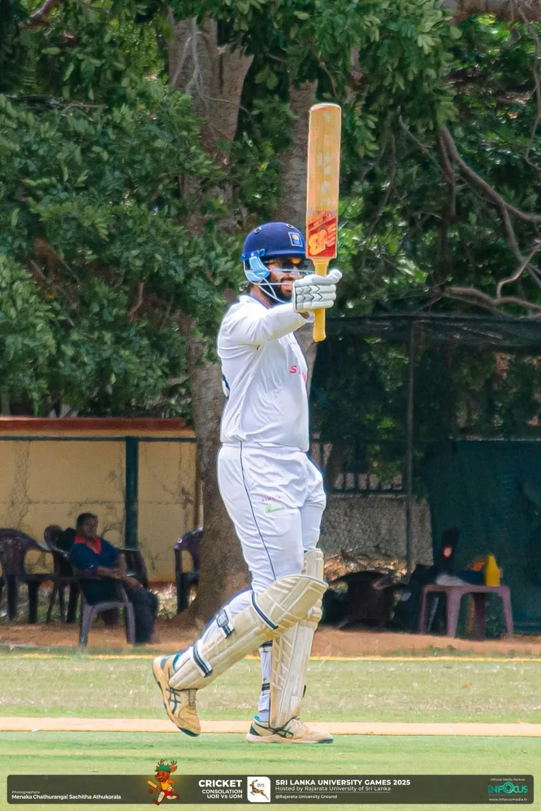 Muftee raising his bat towards the pavilion after reaching a score